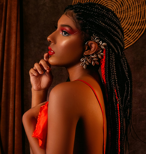 Woman with black and red highlighted braids, bold makeup, and statement jewelry – Braided Aura Nainital
