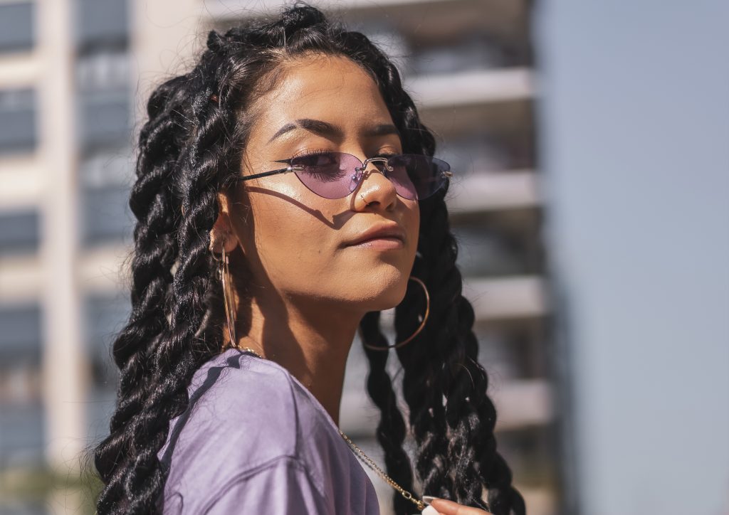 Confident young person wearing chunky twist braids and sunglasses, styled at Braided Aura in Nainital